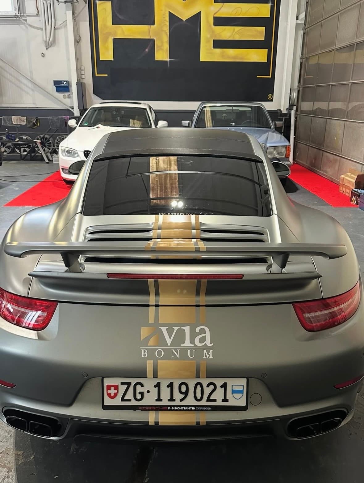 Porsche 911 Turbo S in Satin Grey mit goldenem Pinstripe, Heckansicht in der HME Werkstatt